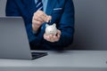 A person is holding a piggy bank, saving money and managing personal finances. Concept of increasing savings and savings by Royalty Free Stock Photo