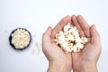 Person holding popcorn in hand top view, with popcorn in bowl isolated on white background Royalty Free Stock Photo