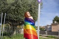 a person holding up a rainbow - colored umbrella and a white pole Royalty Free Stock Photo