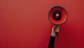 Person Holding Red Megaphone Against Red Background Royalty Free Stock Photo