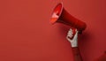 Person Holding Red Megaphone Against Red Background Royalty Free Stock Photo