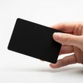 A person holding a sleek black rectangular object against a white background Royalty Free Stock Photo