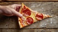 Person Holding Slice of Pizza on Wooden Table Royalty Free Stock Photo