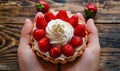 A person holding a small tart with strawberries