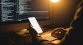 Person Holding Smartphone with Mockup Screen While Coding at Night Royalty Free Stock Photo