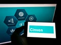 Person holding smartphone with company logo of British private equity firm Cinven Partners LLP on screen in front of website.