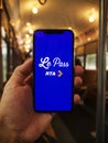 Person holding a smartphone, displaying a le pass rta logo on the screen