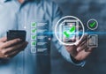 Person holding smartphone interacting with digital checklist and document icons image Royalty Free Stock Photo