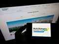 Person holding smartphone with logo of biotechnology company WuXi Biologics (Cayman) Inc. on screen in front of website.
