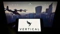 Person holding smartphone with logo of British aircraft company Vertical Aerospace Ltd. on screen in front of website.