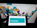 Person holding smartphone with logo of British private equity firm Cinven Partners LLP on screen in front of website.