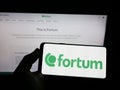 Person holding smartphone with logo of Finnish energy company Fortum Oyj on screen in front of website. Royalty Free Stock Photo