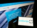Person holding smartphone with logo of Finnish stainless steel producer Outokumpu Oyj on screen in front of website.