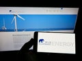 Person holding smartphone with logo of German solar energy company Blue Elephant Energy AG on screen in front of website.