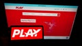 Person holding smartphone with logo of Icelandic low-cost airline company Fly Play hf. on screen in front of website.