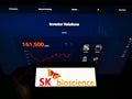 Person holding smartphone with logo of South Korean biological company SK Bioscience Co. Ltd. on screen in front of website.