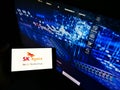 Person holding smartphone with logo of South Korean semiconductor manufacturer SK hynix Inc. on screen in front of website.