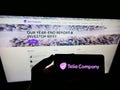 Person holding smartphone with logo of Swedish telecommuncations provider Telia Company AB on screen in front of website.