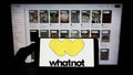 Person holding smartphone with logo of US e-commerce company Whatnot Inc. on screen in front of website.