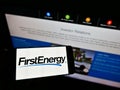 Person holding smartphone with logo of US electric utility company FirstEnergy Corp. on screen in front of website. Royalty Free Stock Photo