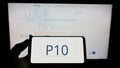 Person holding smartphone with logo of US investment company P10 Holdings Inc. on screen in front of website. Royalty Free Stock Photo