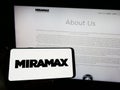 Person holding smartphone with logo of US television production company Miramax LLC on screen in front of website. Royalty Free Stock Photo