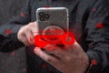 Person holding a smartphone with a red hacked warning and digital lock overlay. Cybersecurity threat, data breach, mobile hacking Royalty Free Stock Photo