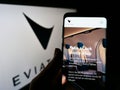 Person holding smartphone with web page of electric aircraft company Eviation Aircraft Ltd. on screen with logo.