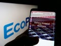 Person holding smartphone with webpage of South Korean company Ecopro BM Co. Ltd. on screen in front of logo.
