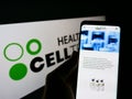 Person holding smartphone with website of biopharmaceutical company Celltrion Inc. on screen in front of logo.