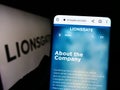 Person holding smartphone with website of Lions Gate Entertainment Corporation (Lionsgate) on screen with logo.