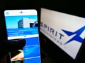Person holding smartphone website logo of US aviation company Spirit AeroSystems Inc. on screen in front of logo.