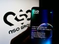 Person holding smartphone with website of technology company NSO Group Technologies Ltd. on screen with logo.