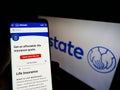 Person holding smartphone with website of US insurance company The Allstate Corporation on screen with logo. Royalty Free Stock Photo