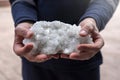 The person is holding some colemanite mineral (bor, boron, borax, ulexite).