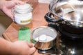 Person holding spoonful mixed baking soda, effective natural cleaning agent