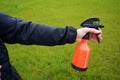 Person holding a spray bottle in hand. Spraying water with spray diffusor. Gardening.