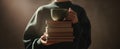 The person holding a stack of books and a coffee mug in a cozy setting.AI generated image Royalty Free Stock Photo