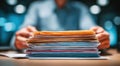A person is holding a stack of papers, which are yellow and blue Royalty Free Stock Photo