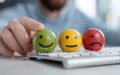 A person is holding three different shaped smiley faces on a keyboard Royalty Free Stock Photo