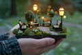 person holding a tiny park with benches and lights Royalty Free Stock Photo