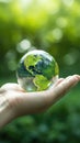 Person is holding up an earth globe in their hand. The globe appears to be made of glass or crystal and has been Royalty Free Stock Photo