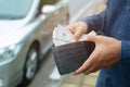 Person holding a wallet in the hands of take money out of pocket stand front car prepare pay by installments - insurance, loan and