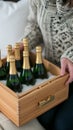 A person holding a wooden crate with six bottles of champagne, AI Royalty Free Stock Photo