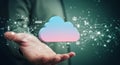 A person holds a digital cloud icon, symbolizing cloud computing or data storage.