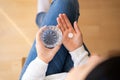 Person holds a glass of water with a round white tablet in hand Royalty Free Stock Photo