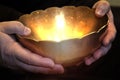 A person holds a magic bowl in his hands, from which a magical light shines