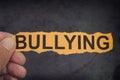 Person holds piece of paper with word Bullying in his hand Royalty Free Stock Photo