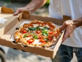 Person holding a pizza in a box Royalty Free Stock Photo