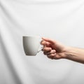 A person holds a plain white ceramic mug against a smooth, light Royalty Free Stock Photo